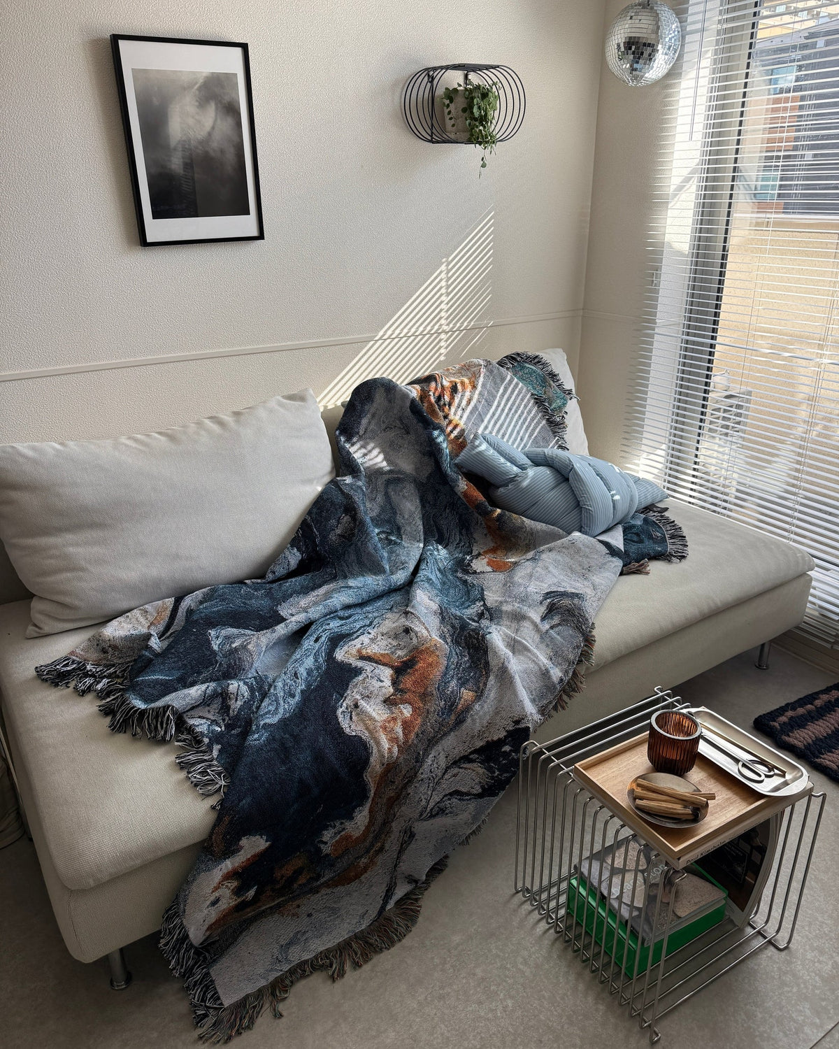 ライトグレーのソファに無造作にかけたNavy Flow Throw Blanket